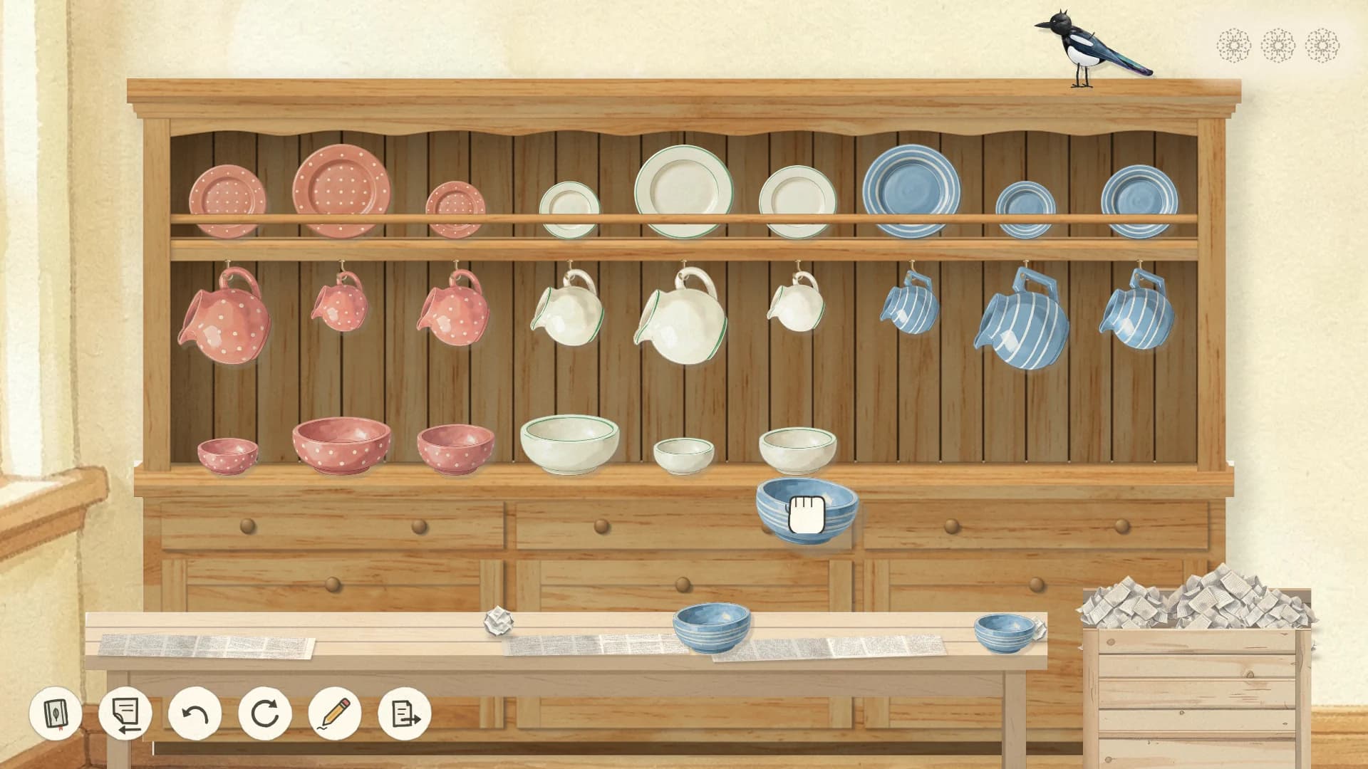 A wooden kitchen dresser with pink, white and blue plates, jugs and bowls in three sets, a blue bowl being lifted onto its shelf and the magpie on top